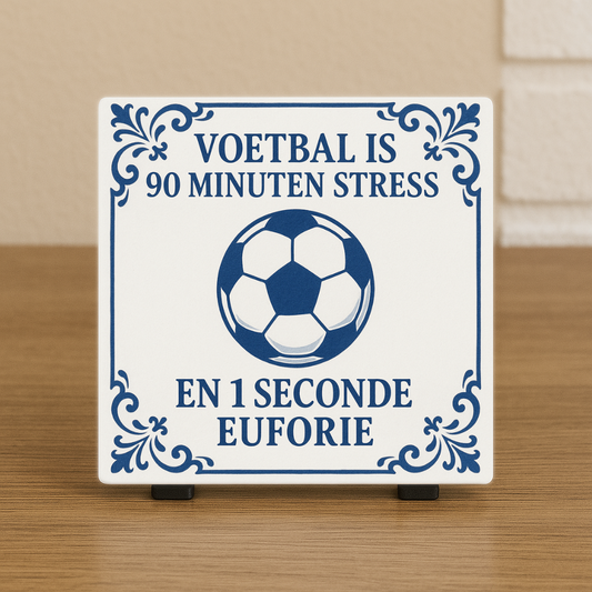 Spreuktegeltje met blauwe decoratieve rand, in het midden een voetbal en de tekst ‘Voetbal is 90 minuten stress en 1 seconde euforie’. Delftsblauw